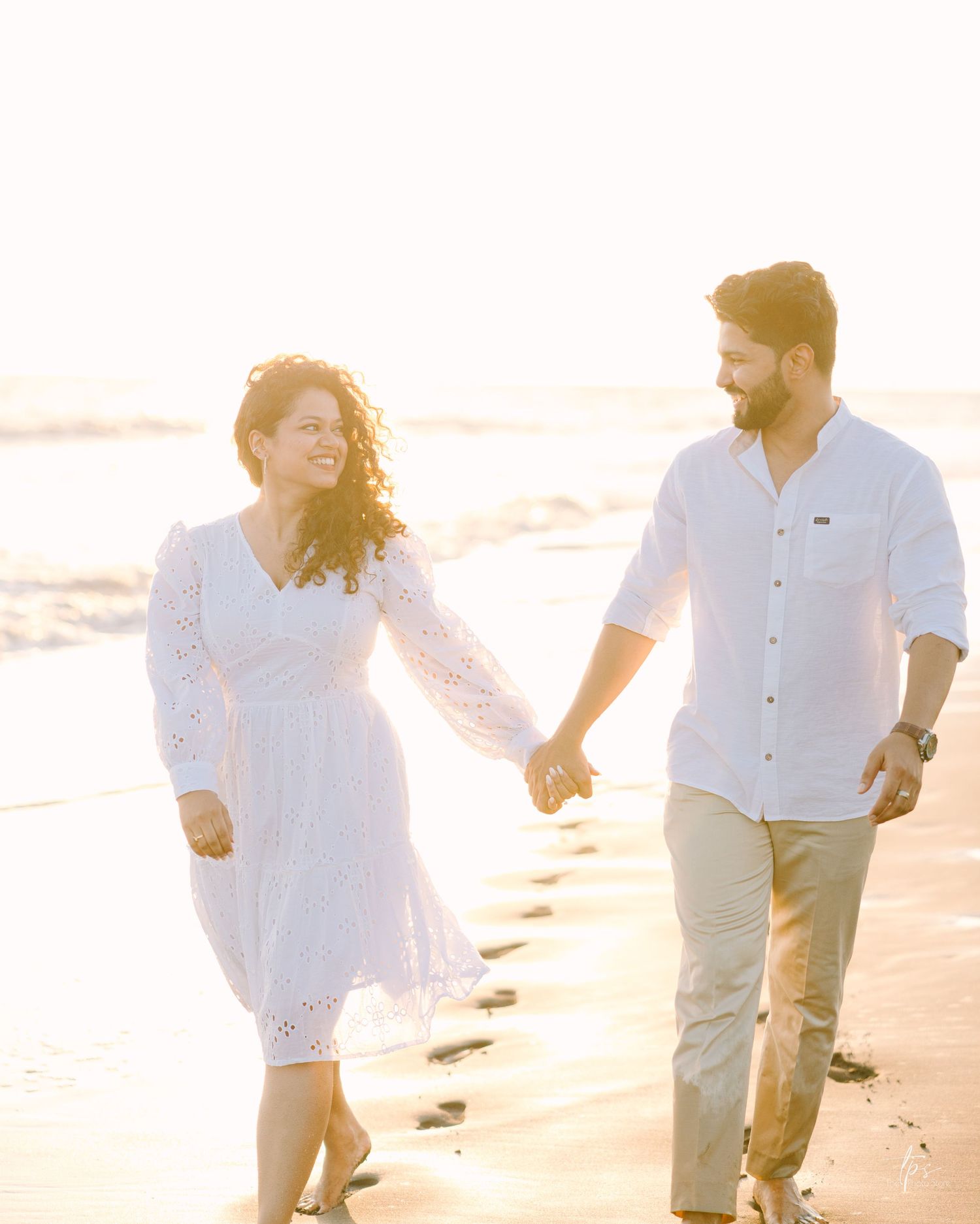 Relaxed beach couple photoshoot in white outfits, captured by a wedding Photographer in Mumbai, your Wedding photographer near me.