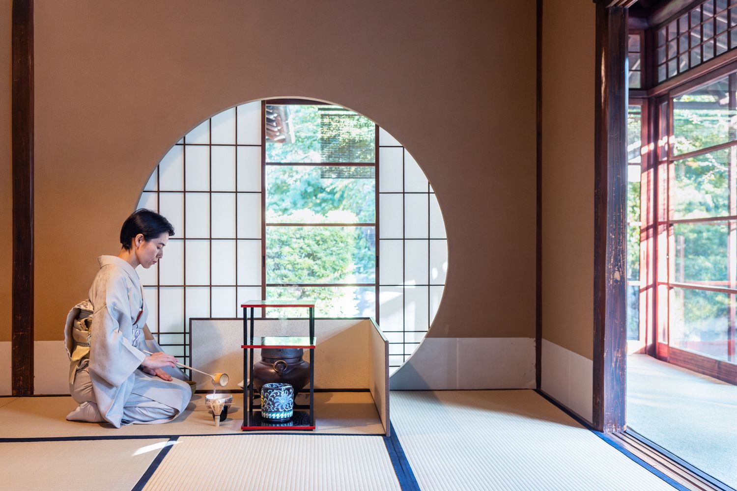 Traditional Japanese tea room interior with circular window and tatami mats.