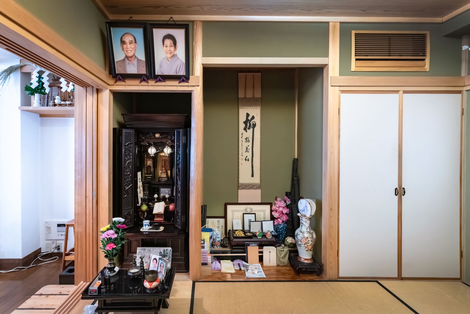Traditional Japanese room with Buddhist altar and family portraits.