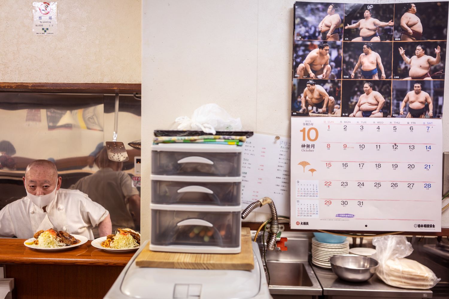 Restaurant kitchen counter with calendar and storage drawers.