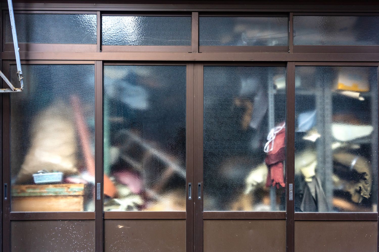 Blurry view through window panes showing silhouettes and reflections.