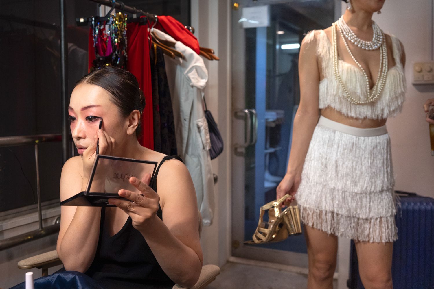 Backstage scene showing costume preparations and dressing room ambiance.