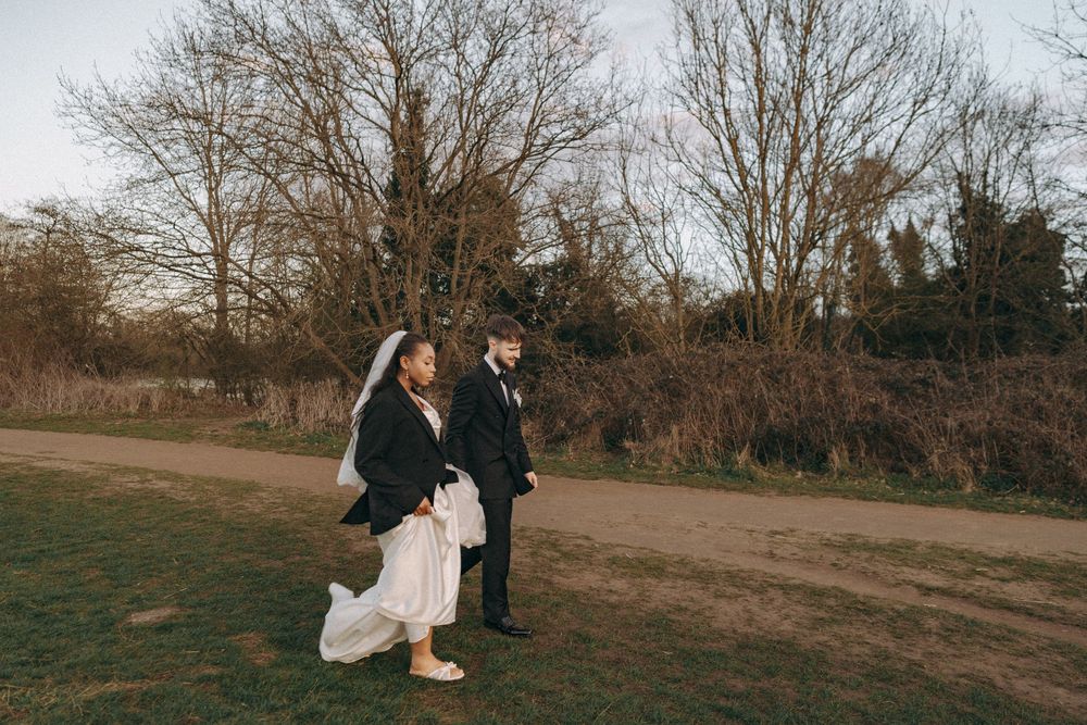 Bride & groom walking on a field