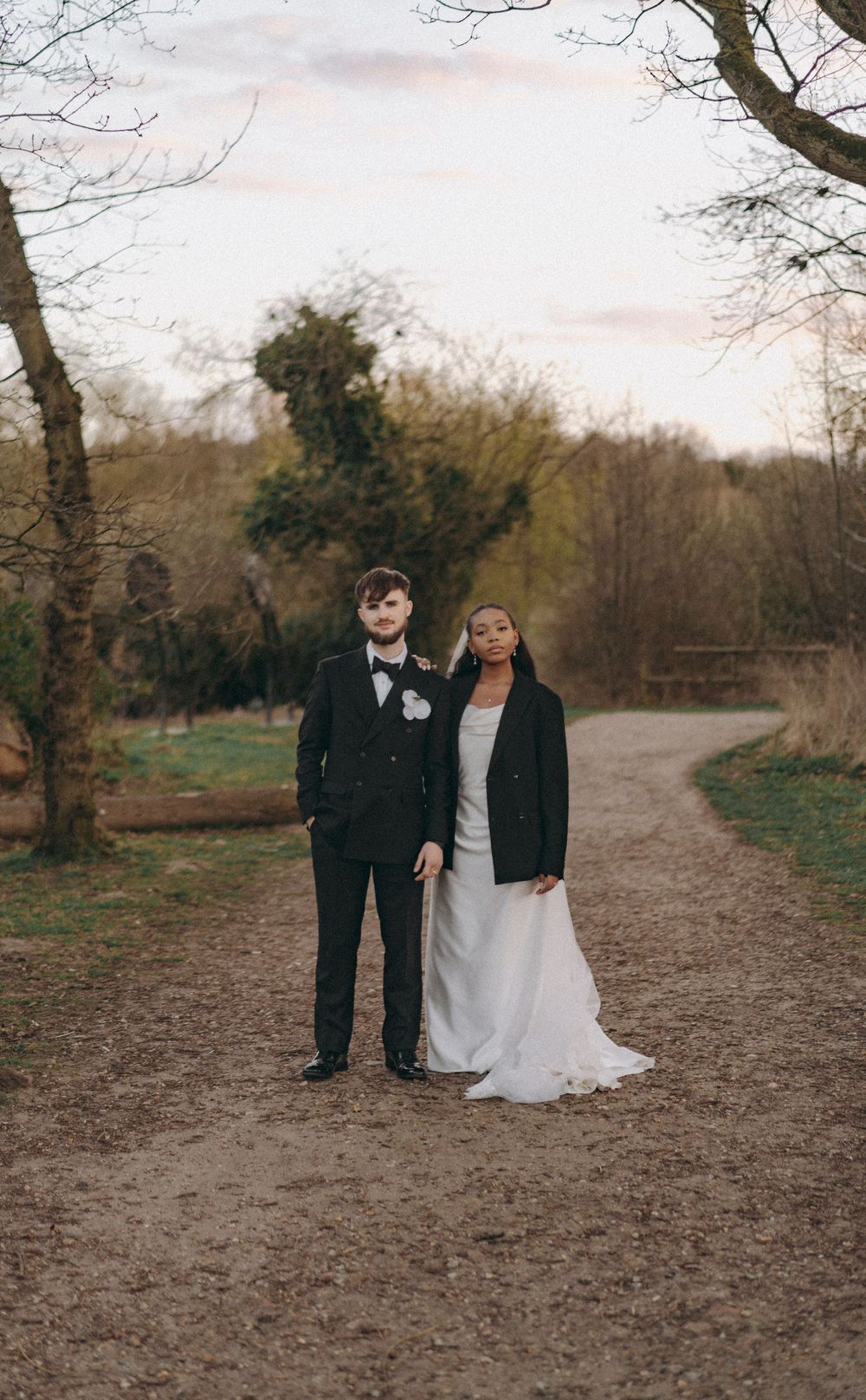 Portrait of Bride & Groom, bride wearing a blaze over her wedding dress. Editorial wedding