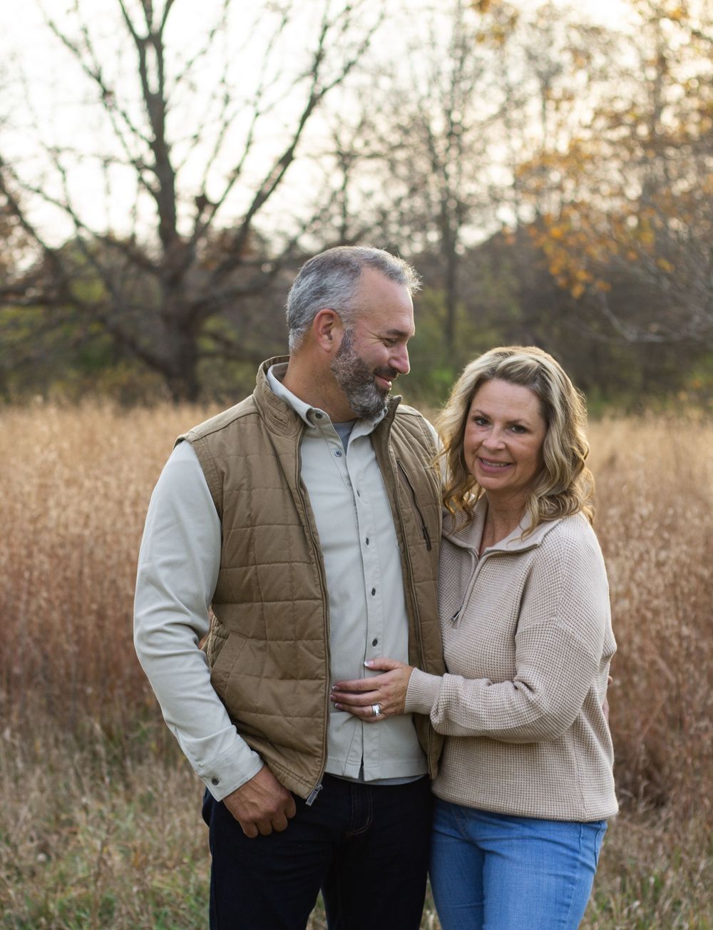 A group of people pose together in a rustic outdoor setting during golden hour for family portraits.