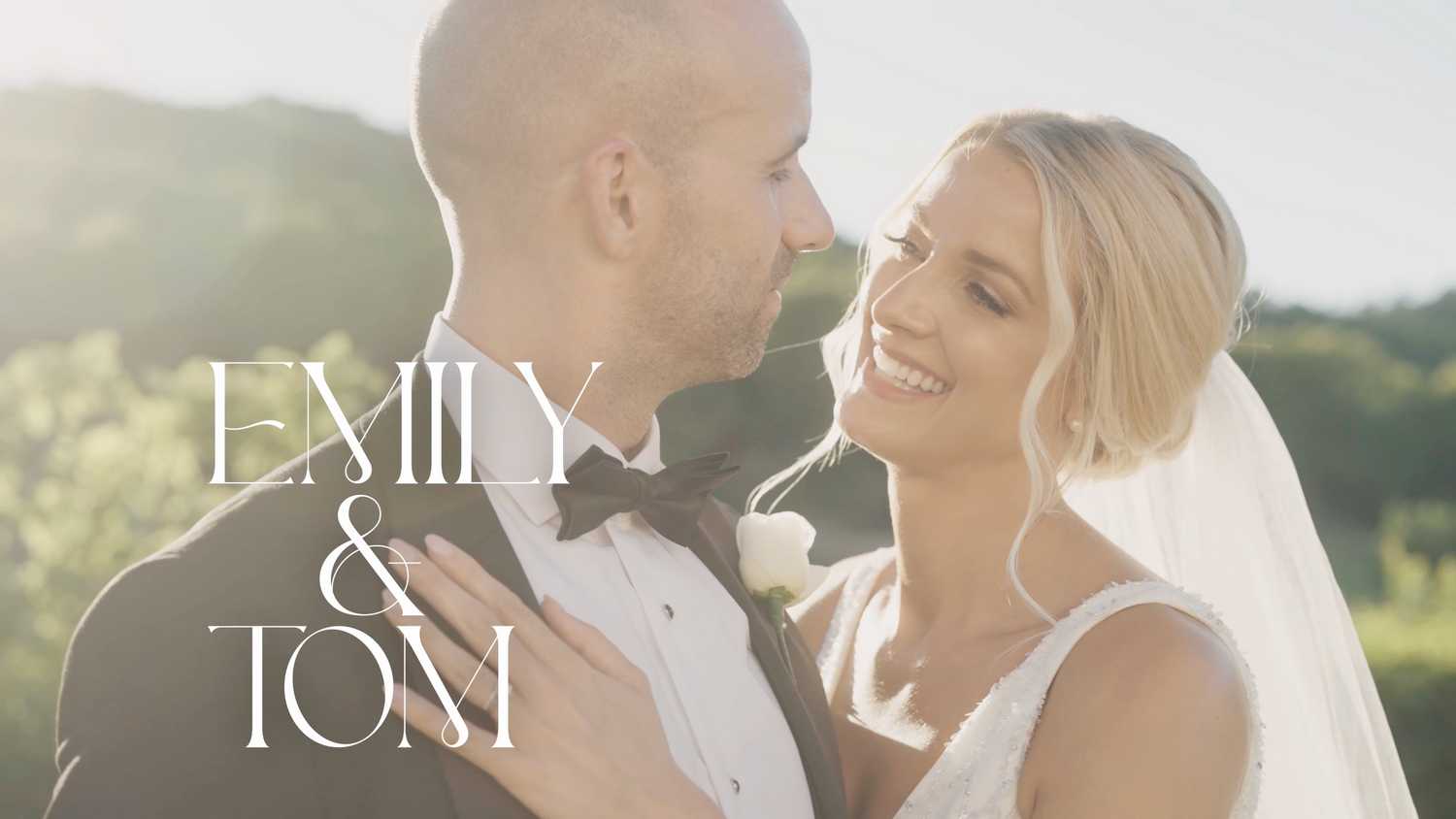Bride and groom smiling and looking at each other with love under the golden sunset light.