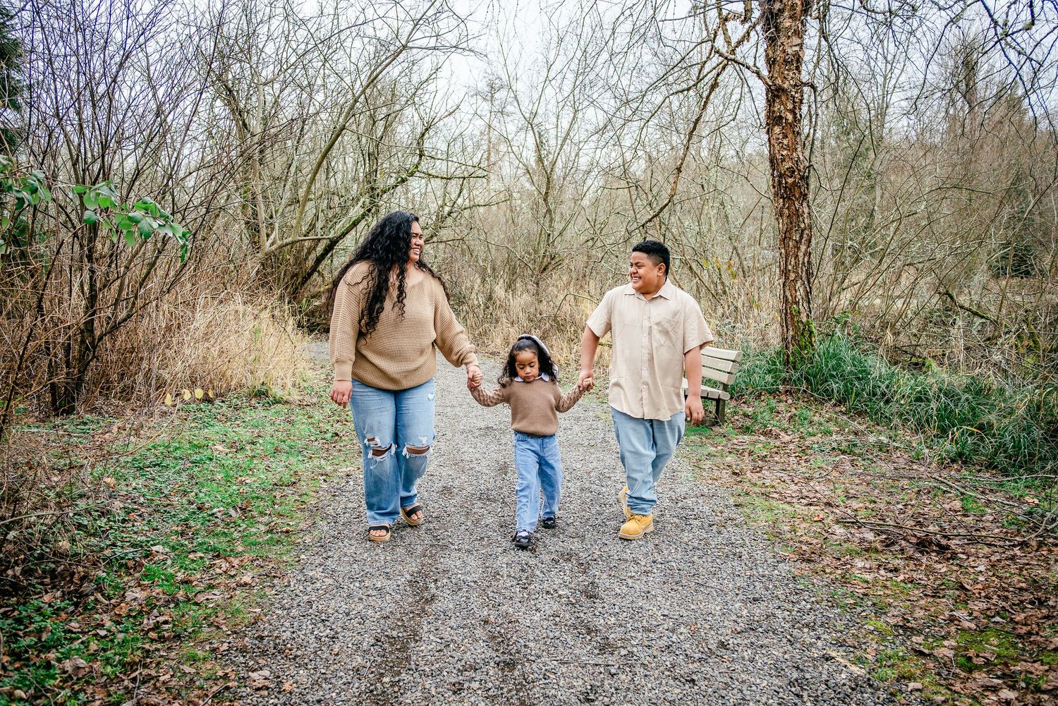 Family walking along a wooded trail at DeCoursey Park during a winter family photo session