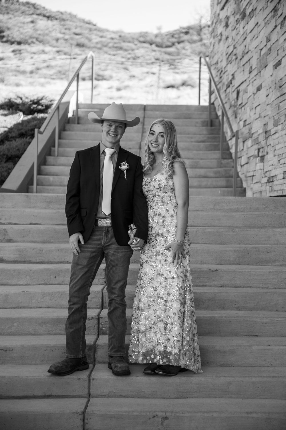 Prom couple standing on stairs.