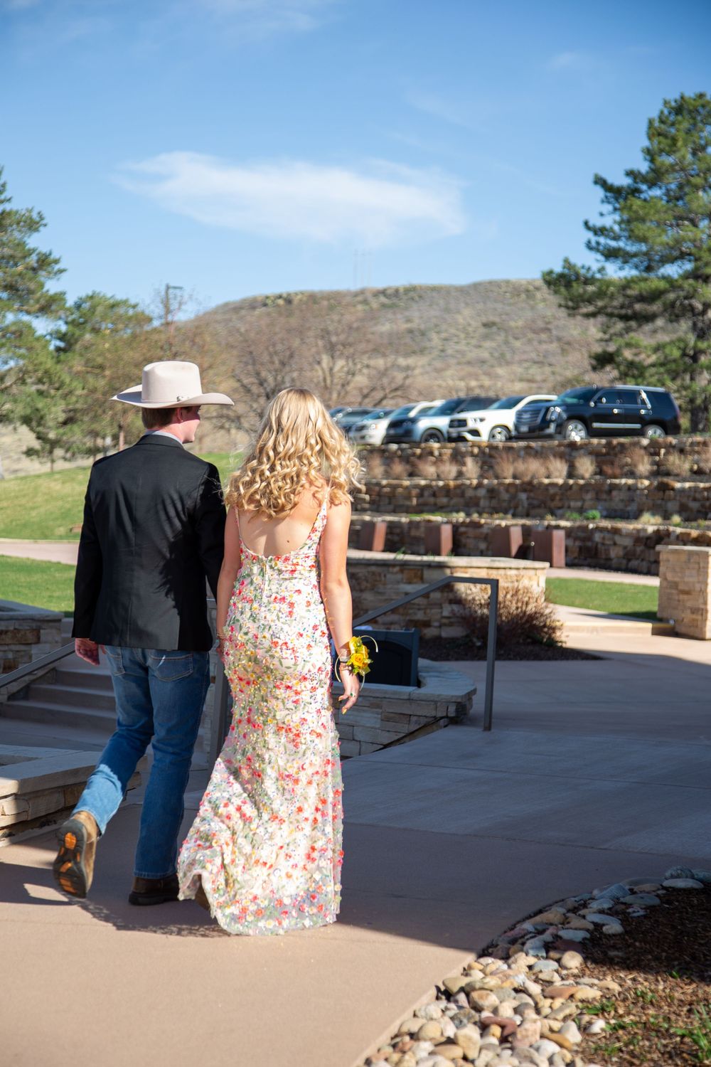 Prom couple walking away on path.