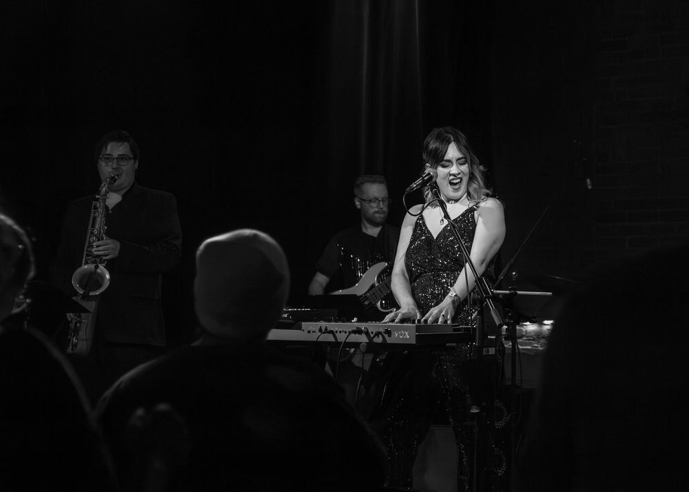 Lead vocalist singing while playing piano.