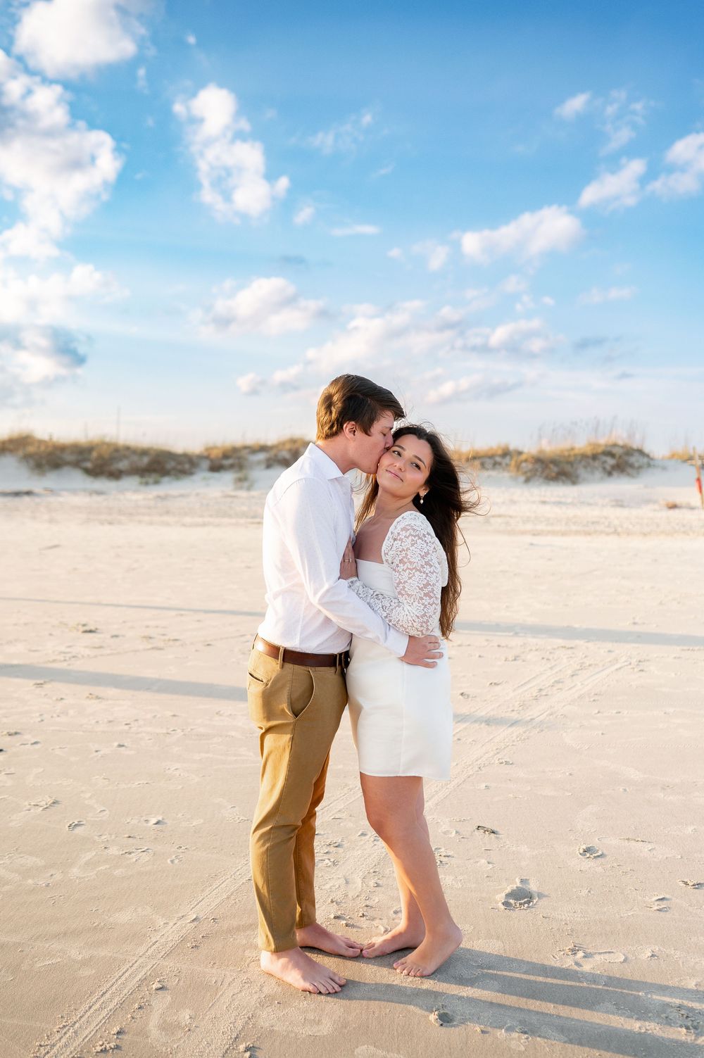Playful beach photoshoot sequence showing couple in white and tan clothing on sandy shore.
