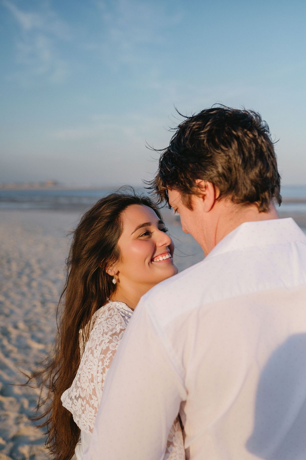 Intimate beach portraits capturing romantic moments with ocean backdrop.