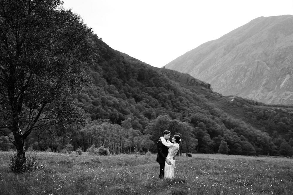 Dramatic black and white mountain landscape with rolling hills and cloudy skies.