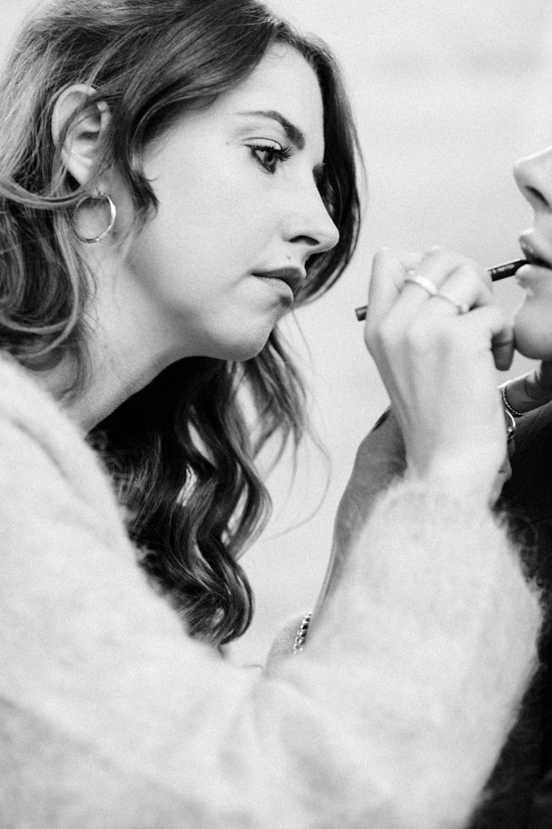 Stylistin beim Styling und Make-up der Braut während der Hochzeitsvorbereitungen.