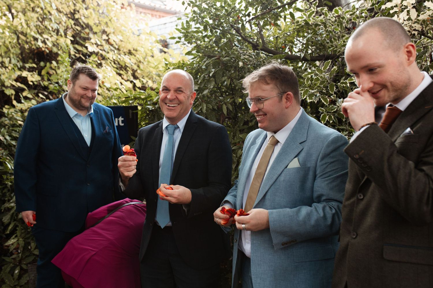 A group of people in business attire laughing and socializing at an outdoor gathering.