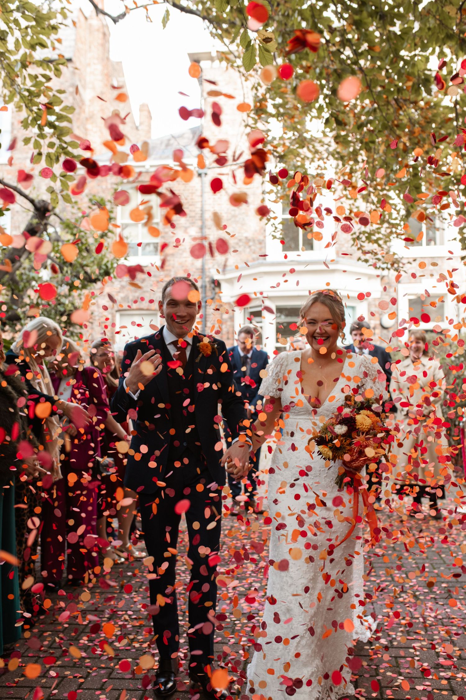 Wedding celebration sequence showing rose petals raining down on a couple during their joyful outdoor ceremony exit.