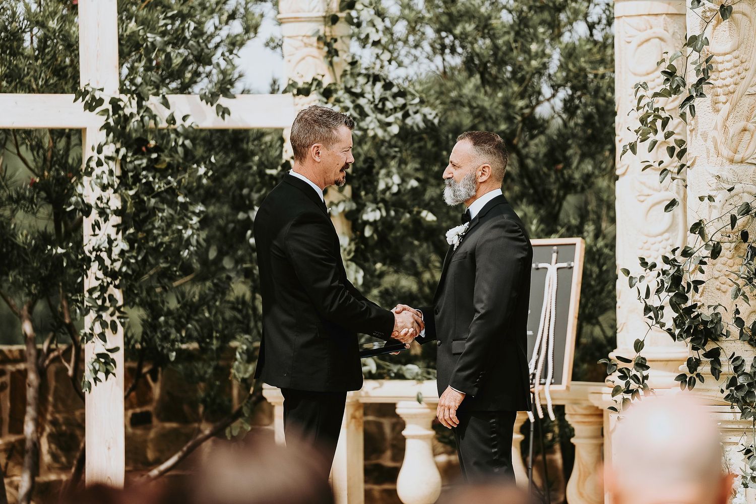 Groom watching bride walk down the aisle at vineyard venue