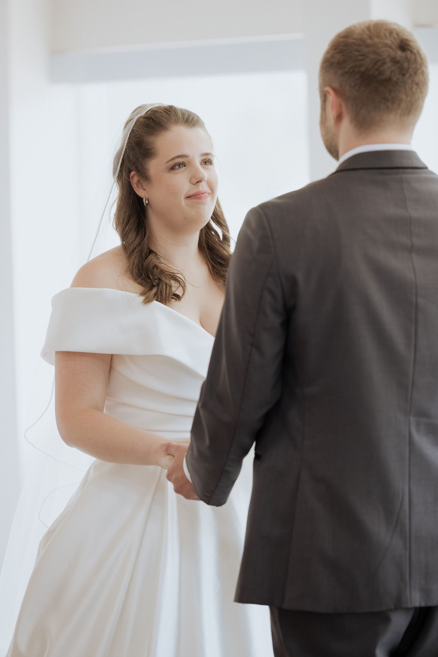 bride and groom hold hands during vows during summer indoor wedding ceremony, New Brunswick wedding photographer, full day wedding packages