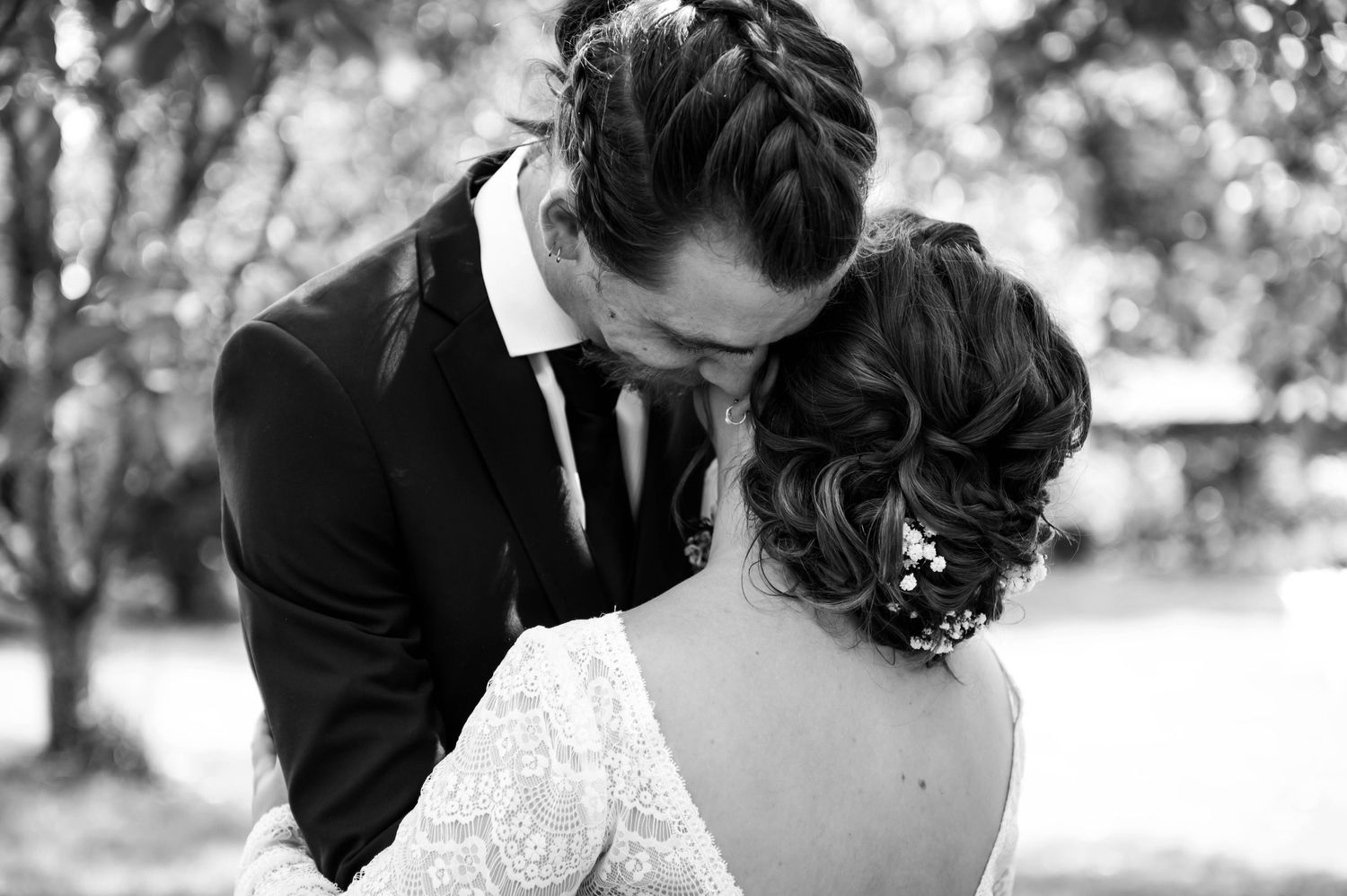 Couple de mariés en noir et blanc partageant un moment tendre lors d’une séance photo de mariage en Bretagne.