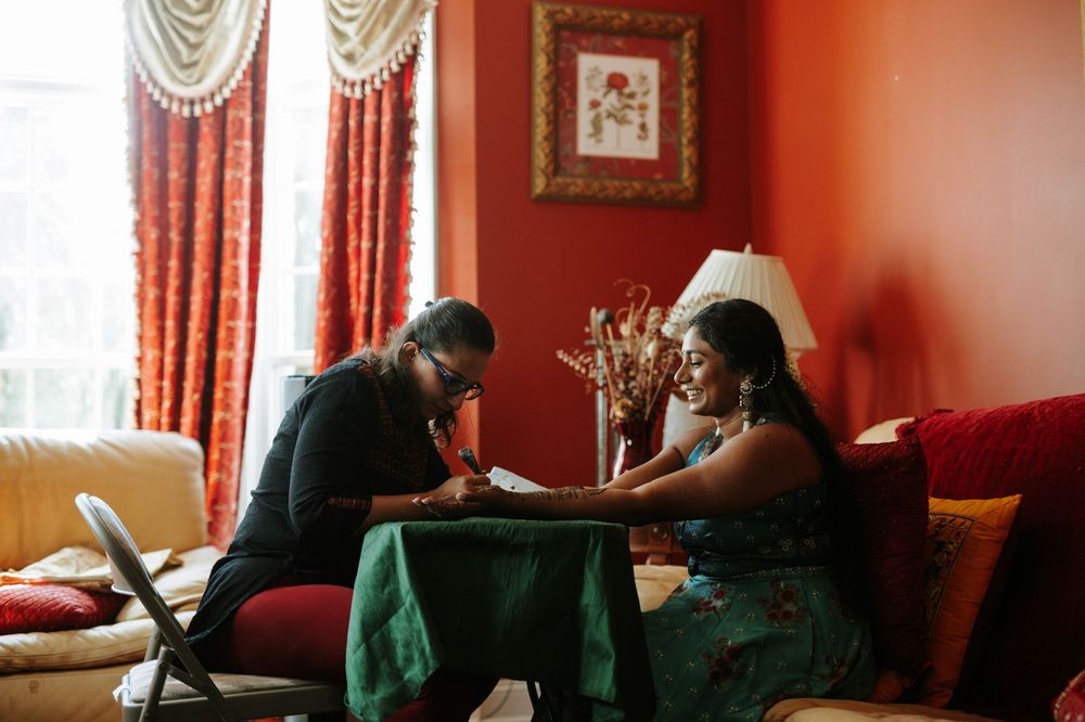 A series of images showing a couple sitting on a red couch in a living room with curtained windows.