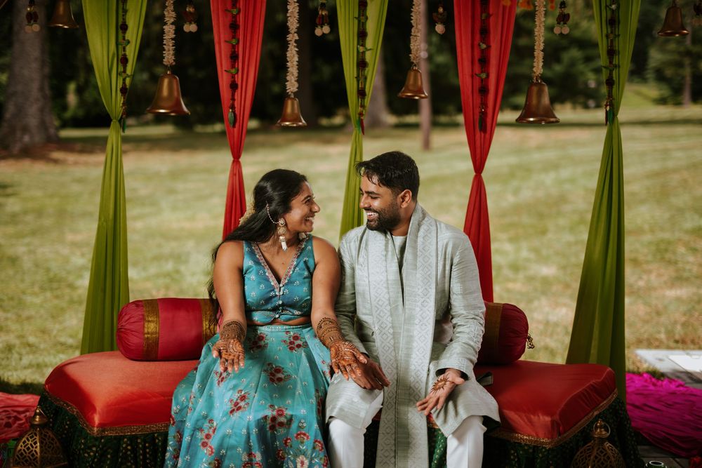 Colorful outdoor wedding ceremony setup with yellow and red decorative elements and floral arrangements.