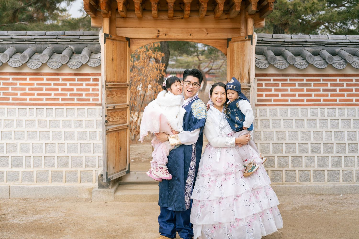 People in traditional Korean hanbok clothing pose together at Gyeongbokgung Palace in Seoul.