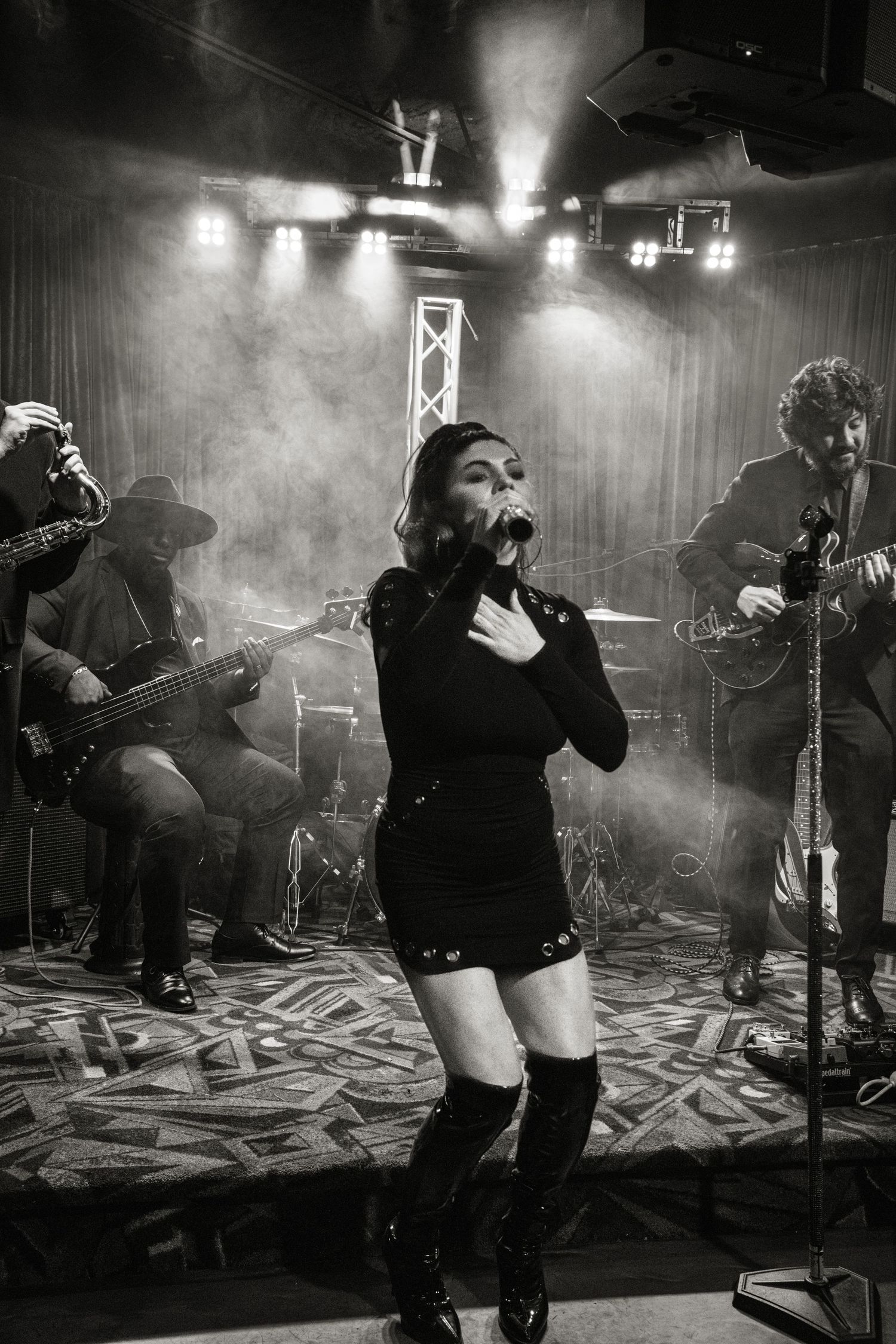 Black and white photo sequence of a rock band performing on stage with dramatic lighting and smoke effects.