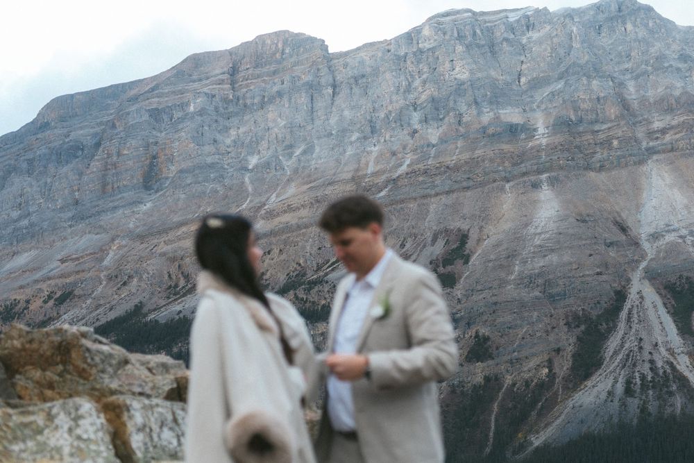 photo of a mountain in Banff National Park with an out-of-focus bride and groom in the foreground