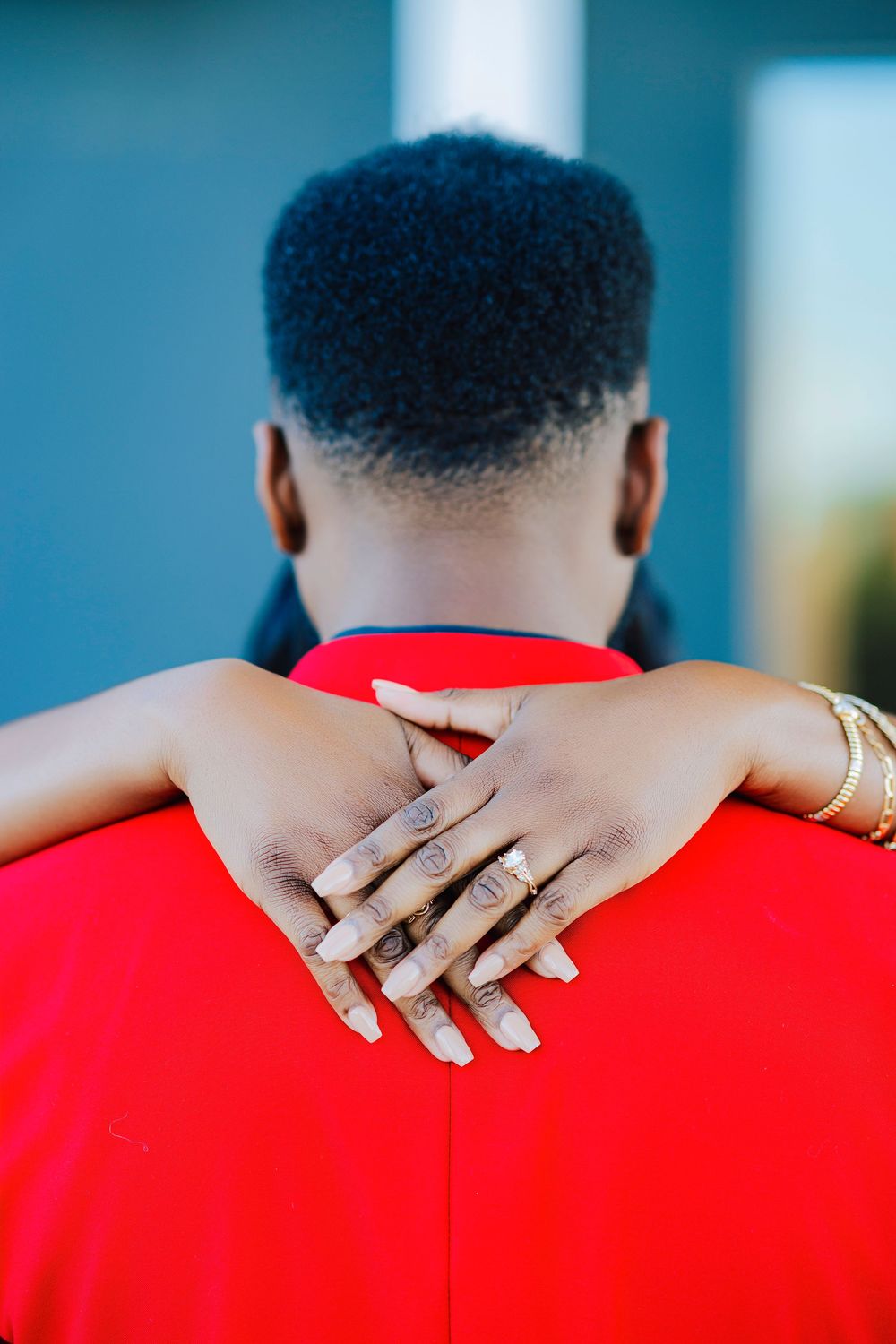 A person wearing a bright red shirt places their hand with multiple rings on their shoulder in a sequence of photos.