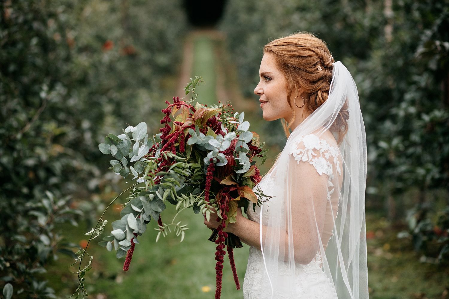 A low bun with soft waved tendrils. The brides lovely Auburn hair looked perfect for this autumn Surrey wedding