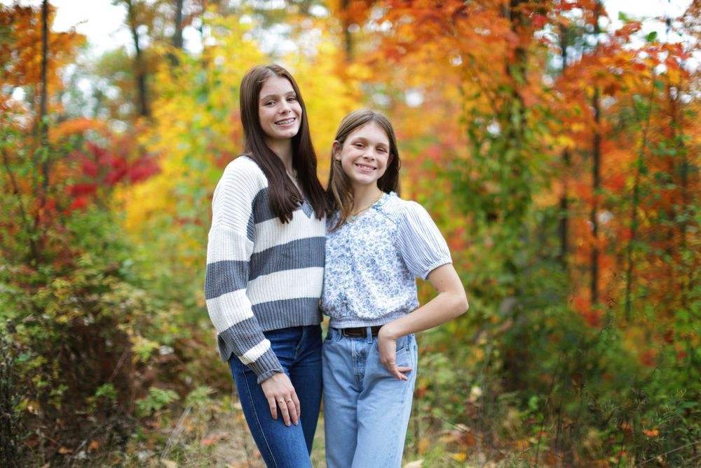 People enjoying a vibrant autumn day surrounded by colorful fall foliage in a park setting.