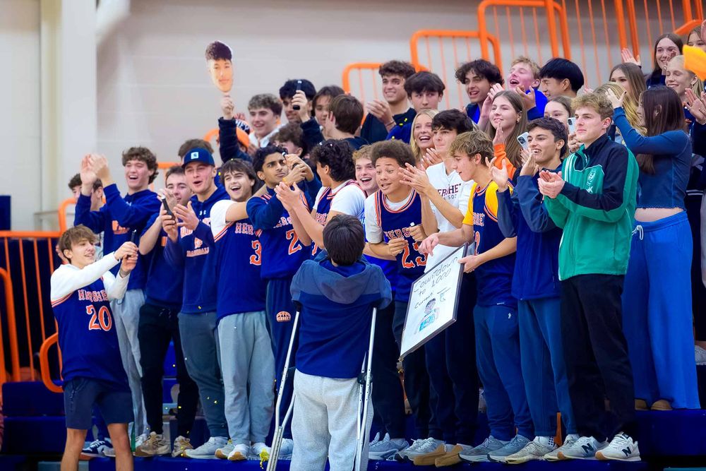 Hershey High School fans cheer and clap in the bleachers during Cam Sweeney’s 1,000th point celebration.