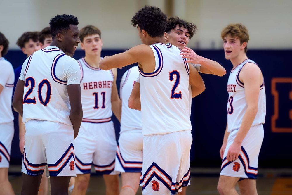Hershey basketball team gathers in a huddle to celebrate Cam Sweeney’s 1,000th point achievement on the court.