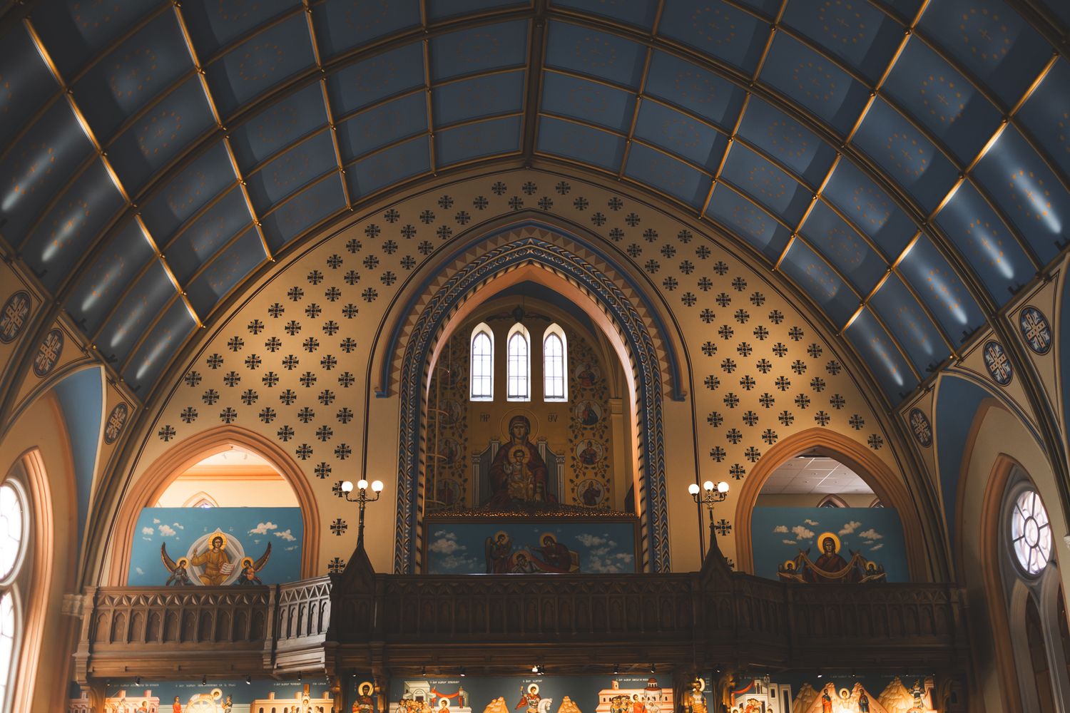 A panoramic view of an ornate church interior with arched ceilings, stained glass windows and decorative architectural details.