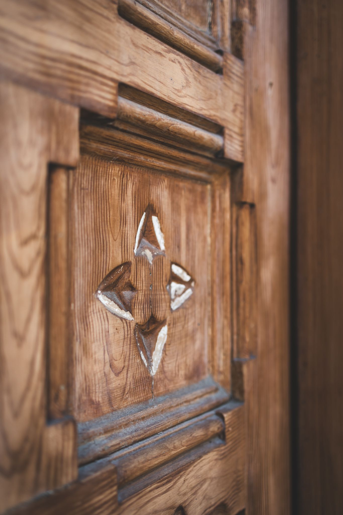 Wooden cabinet door handles shown in progression from blurred to focused in a stylistic photography sequence.