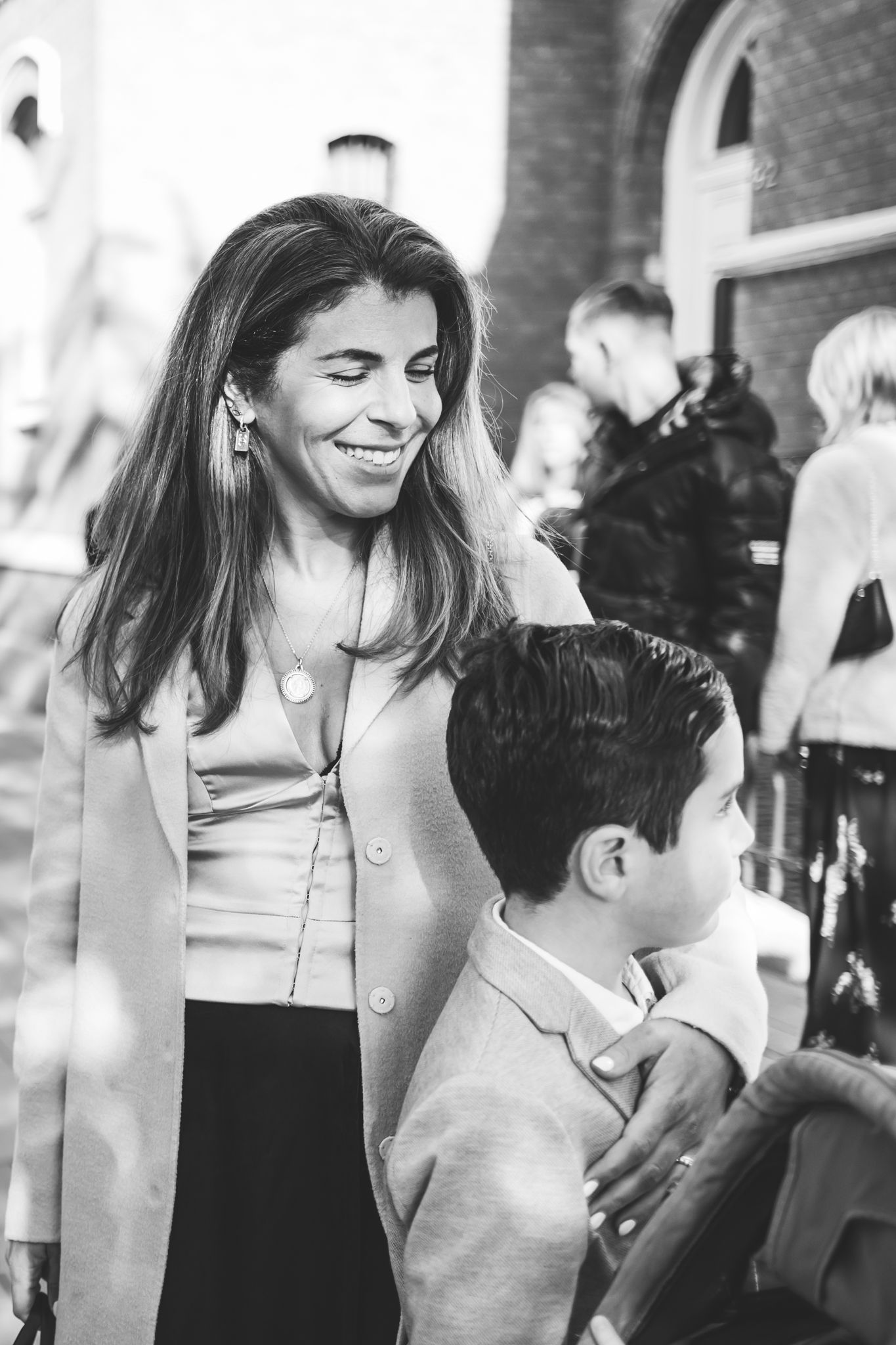 A couple shares a joyful moment together at an indoor event, captured in black and white photography.
