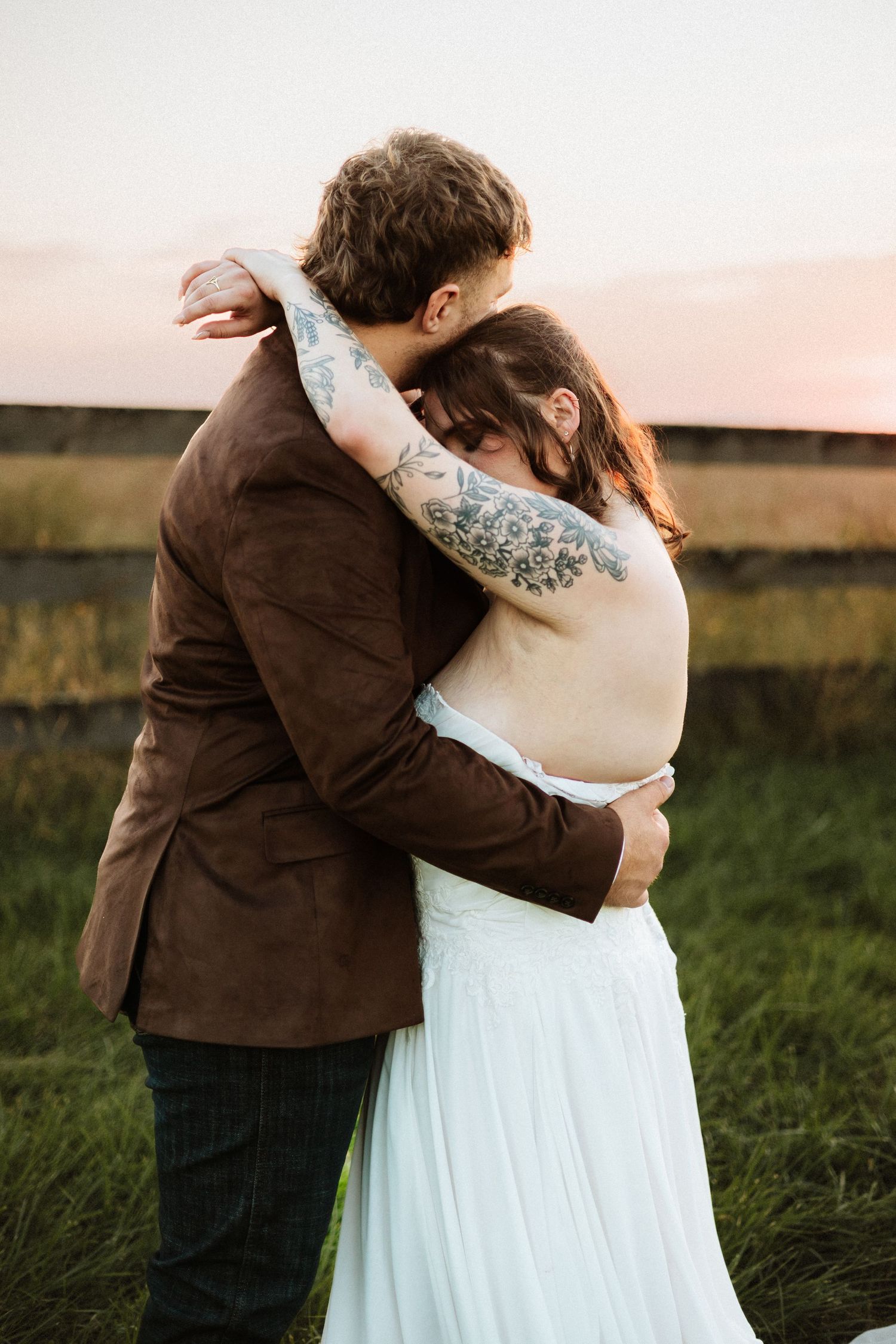A bride leans into her groom at Stone Ridge Estates during sunset.