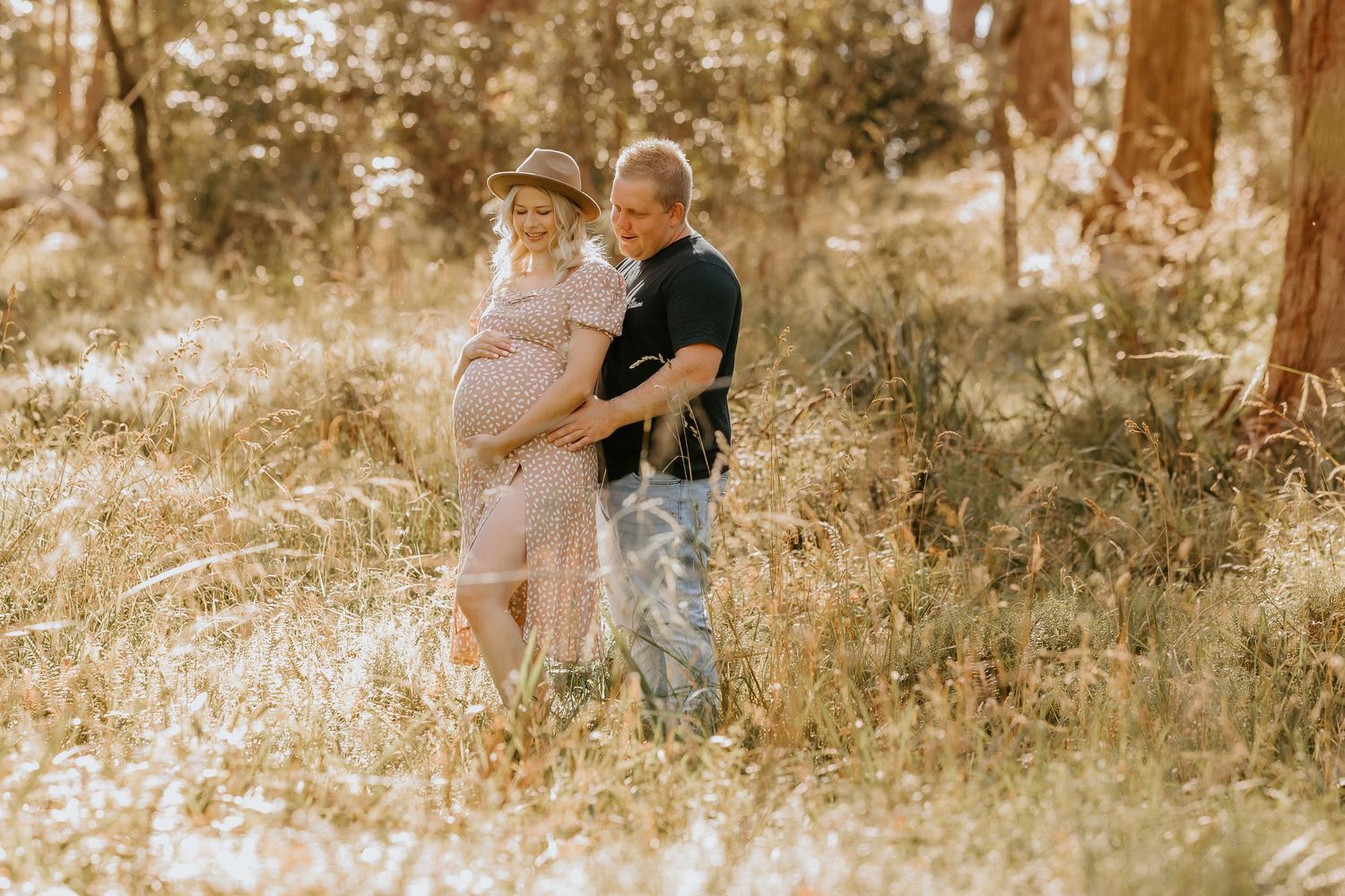 A family enjoys a warm autumn day in a sunlit forest setting during a lifestyle photography session.