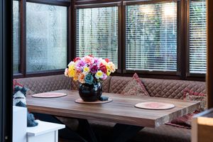 Breakfast nook with quilted banquette seating and colorful floral centerpiece.