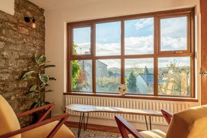 Modern living room with large windows offering scenic mountain views and natural light.
