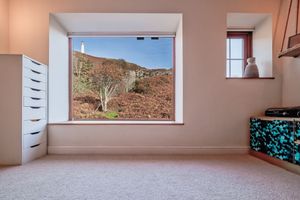 Minimalist interior space with horizontal windows providing views of red cliffs and natural landscape.
