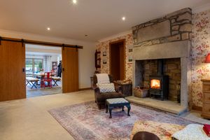 Cozy living room with stone fireplace, barn door, and patterned area rug.