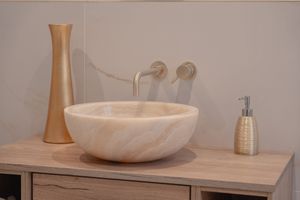 Modern bathroom interior with white vessel sink and wooden vanity in minimalist style.