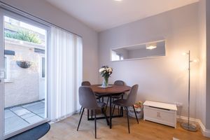 Open concept living and dining area with white walls and large sliding glass doors.