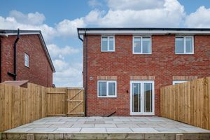 Row of new brick houses with modern windows and fencing.
