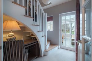 Elegant staircase with under-stair storage space and French doors leading to the exterior.