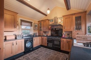 Traditional kitchen with wooden cabinets, black countertops, and classic appliances.
