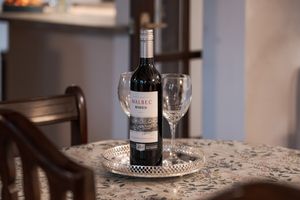 Elegant table setting with wine bottles and glasses on a lace tablecloth.