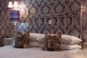 Luxurious interior space with ornate damask wallpaper and decorative elements.
