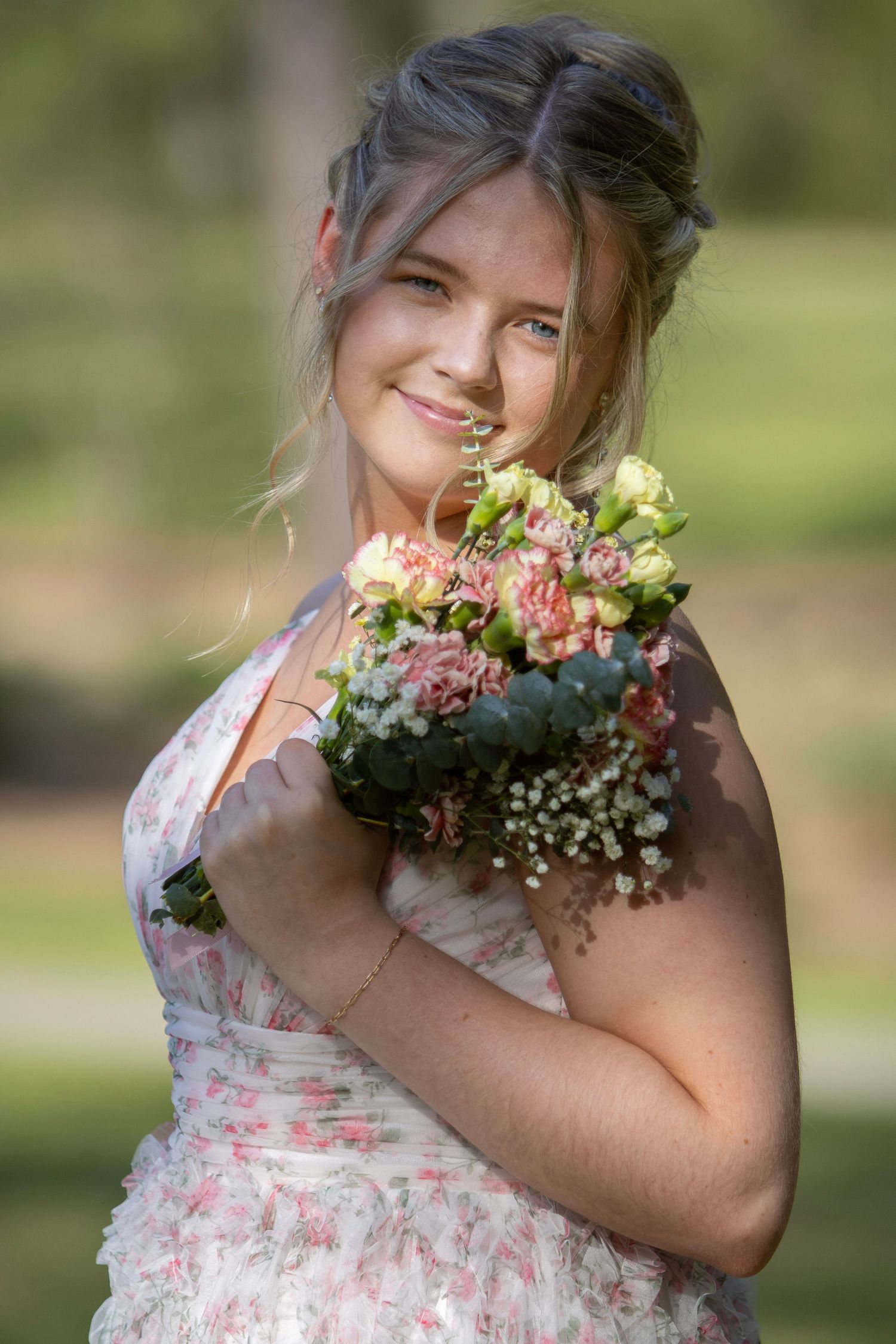 A series of photos showing someone in a floral dress holding a bouquet of pink and white flowers in an outdoor setting.
